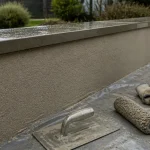 Crépi muret fraîchement appliqué sur muret en extérieur, sous pluie froide